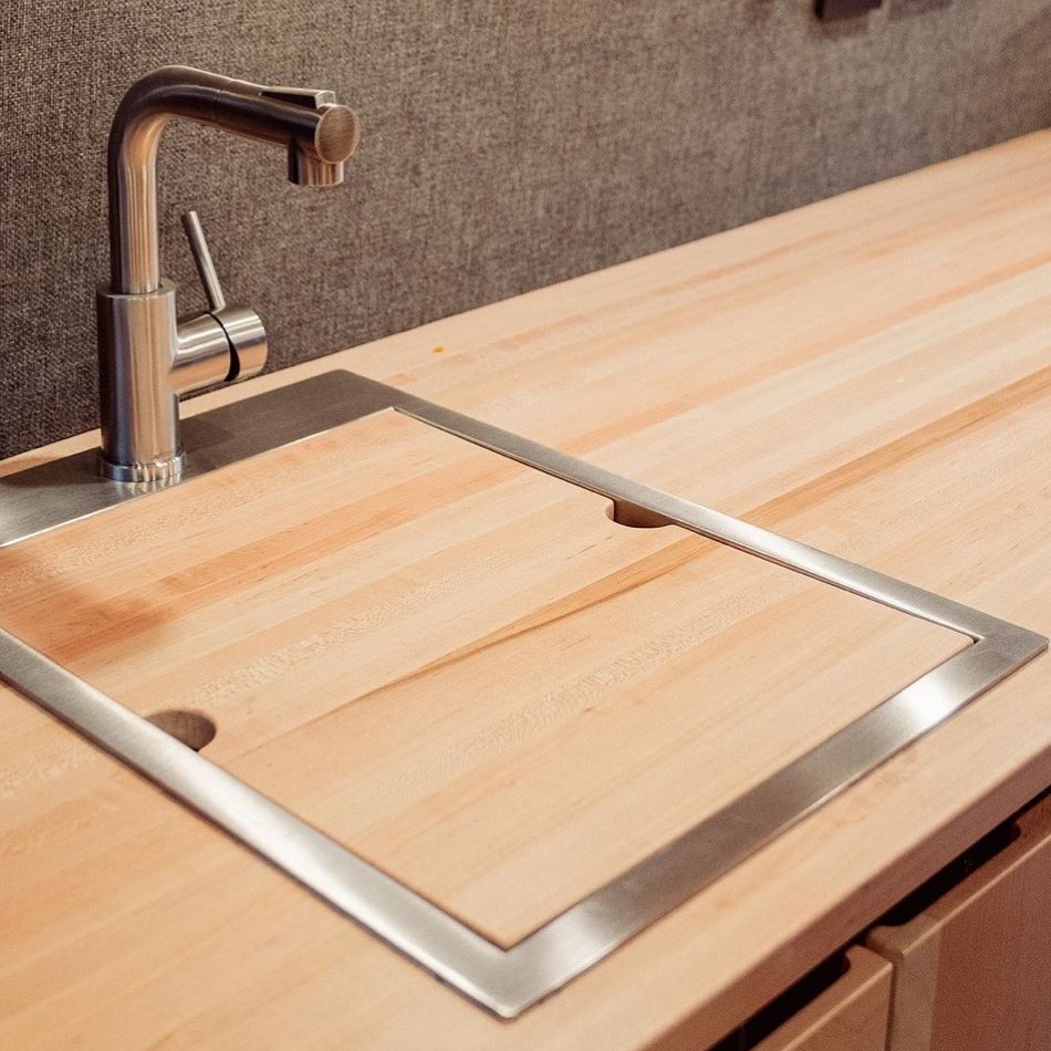 Ruvati Workstation Sink with wooden cutting board over top. 